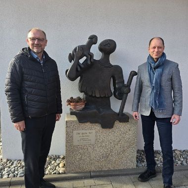 Der aktuelle Stiftungsvorstand, bestehend aus Peter Ehmann (li) und Volker Göbel (re), vor der Originalplastik „Der gute Hirt“ welche von Max Walter aus Werneck gestaltet wurde und vor dem Eingangsbereich der Tagespflege „Der gute Hirte“ der Caritas in Ebermannstadt steht.